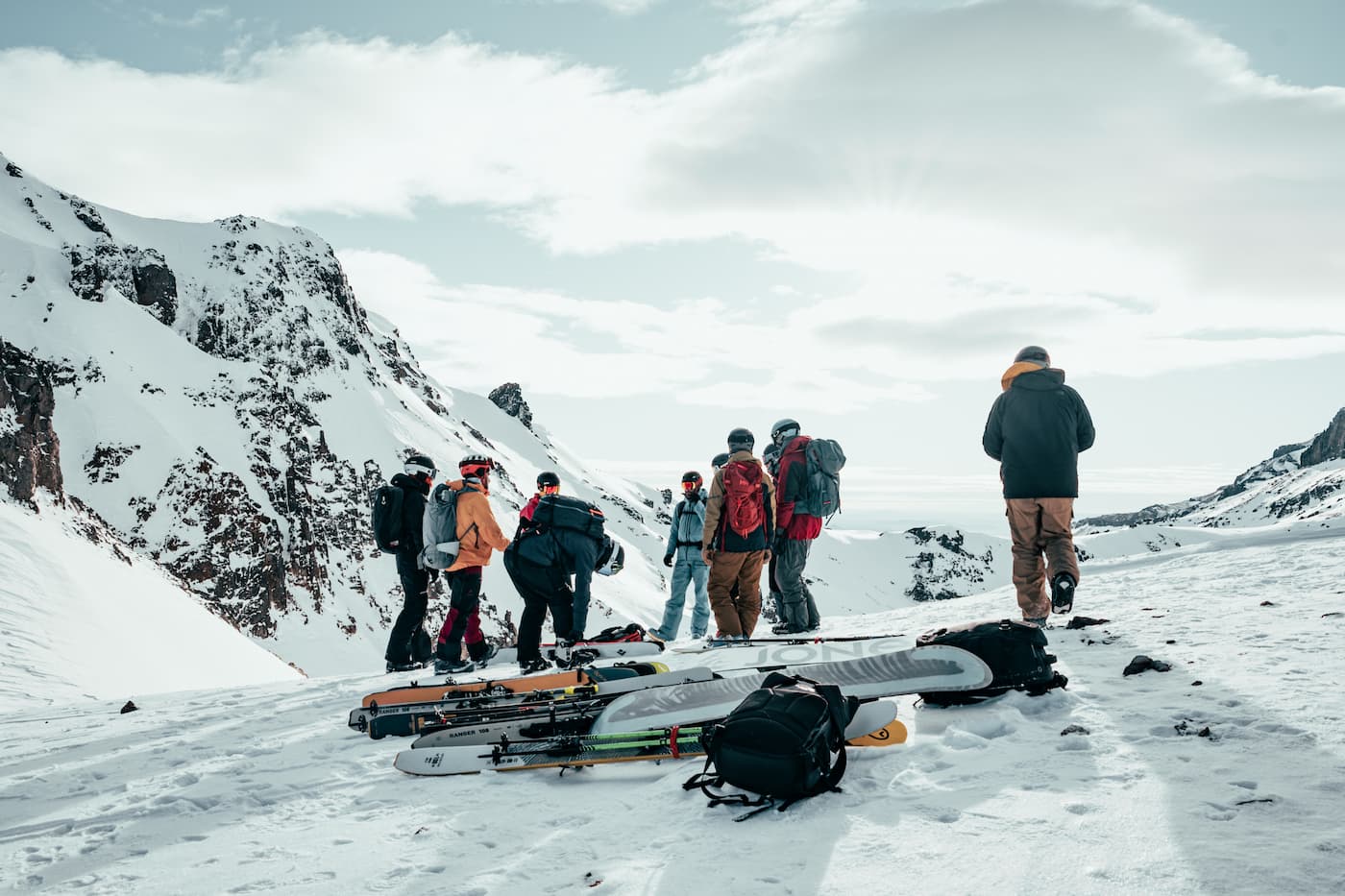 Mountain explorers preparing alpine ski gear on a snowy high-altitude ridge